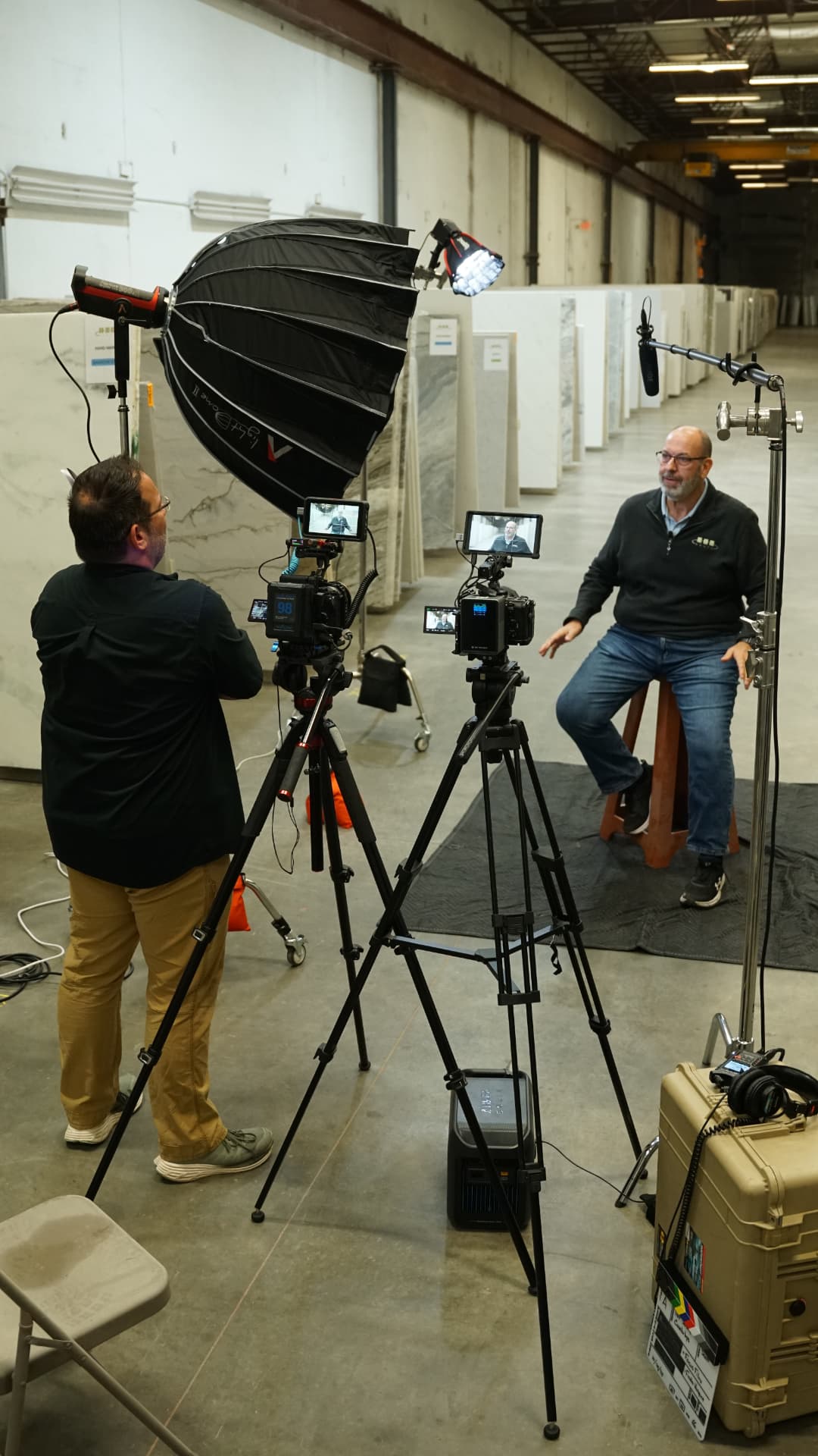 Focus Films crew filming an interview on location with cinema cameras, boom mic, and softbox lighting